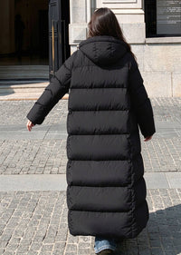 Full length back view of woman walking in black 50 inches length hooded duck down puffer coat