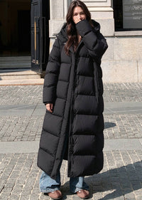 Full length front view of woman wearing open black 50 inches length hooded duck down puffer coat outdoors