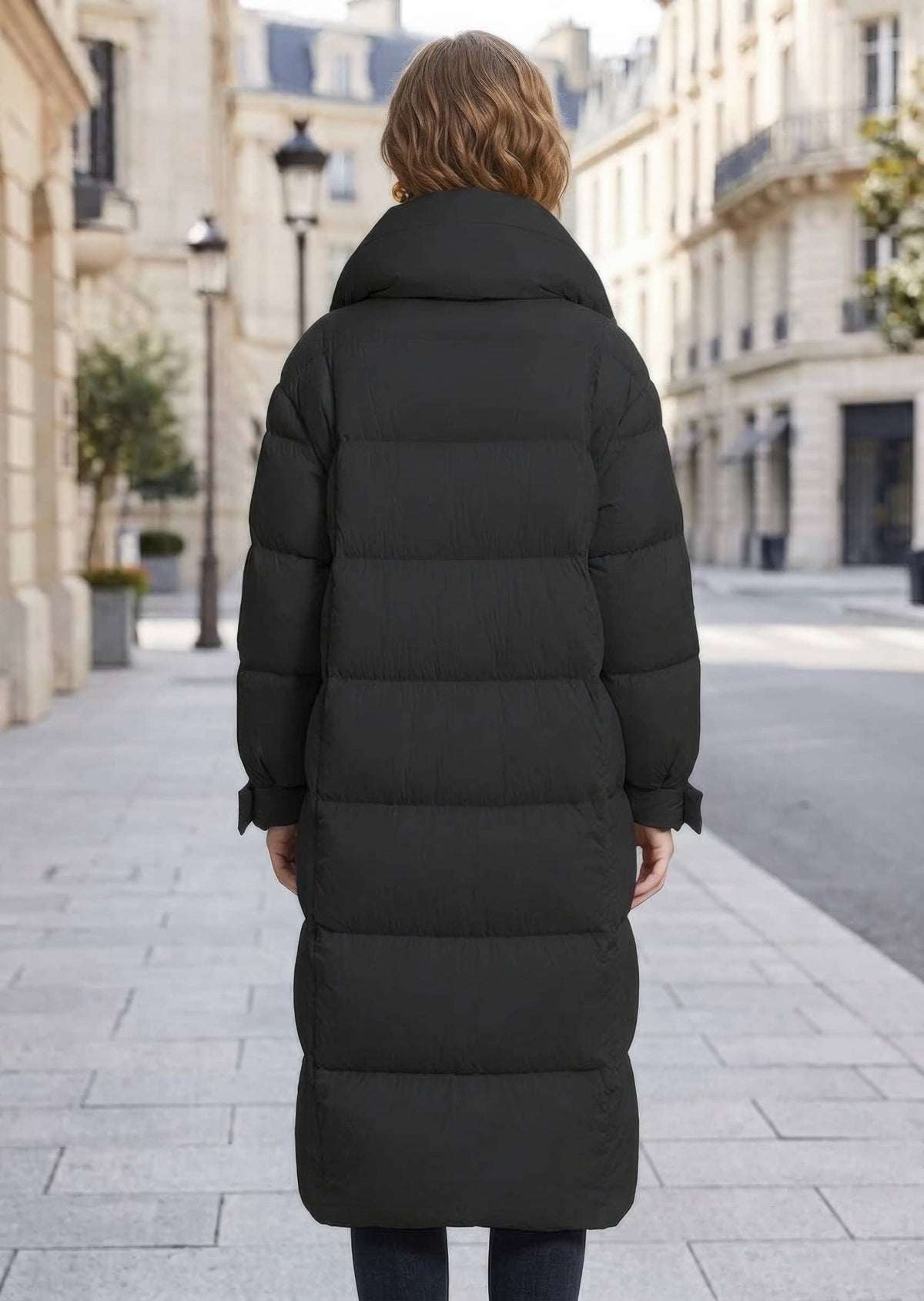 Back view of woman wearing black longline quilted down puffer coat with stand collar