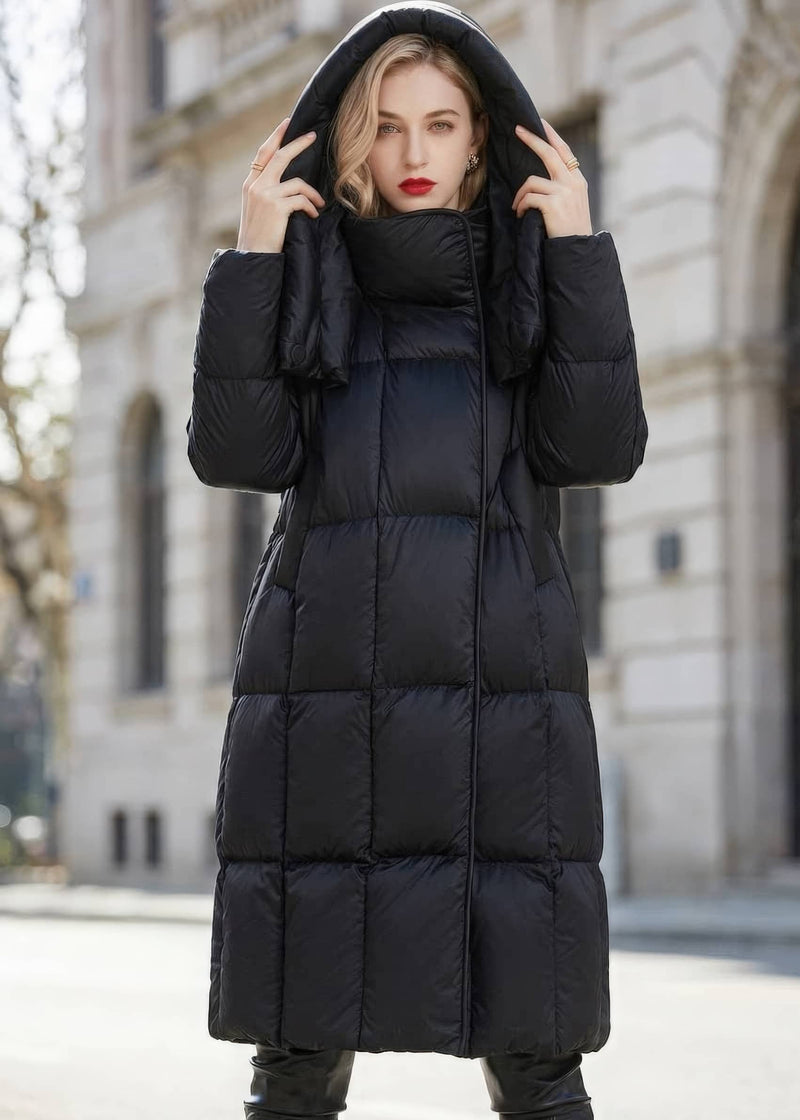 Woman holding the sides of her hood wearing a black long quilted down puffer coat