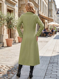 Full back view of woman wearing sage green double-breasted long coat with structured seams