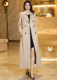 Front view of a long khaki trench coat styled open to showcase professional high-end women's apparel.