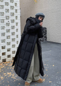 High collar windproof styling on women's oversized black duck down maxi puffer coat outdoors.
