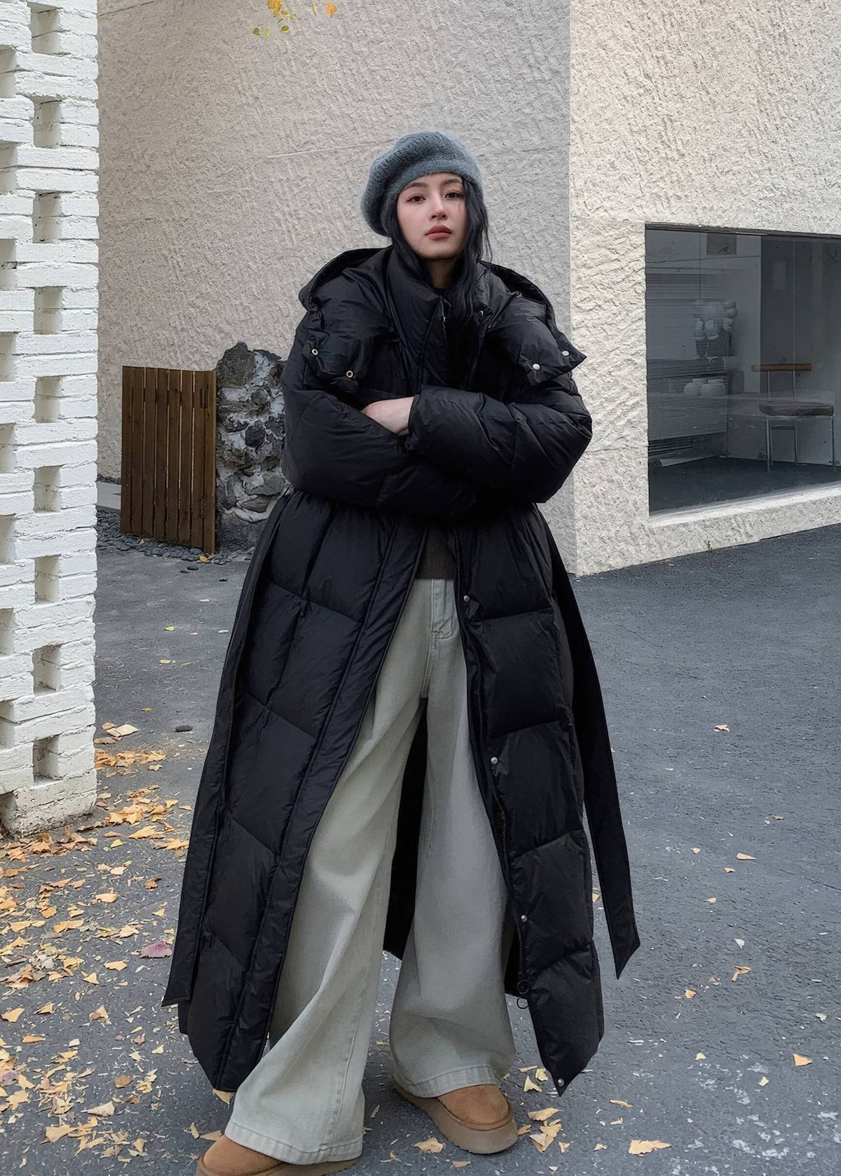 Open-front styling of longline black quilted down coat worn with wide-leg trousers and platform boots.