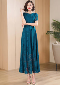 Full-length front view of a model wearing the Elegant Green Floral Jacquard Maxi Dress with a matching satin waist tie.