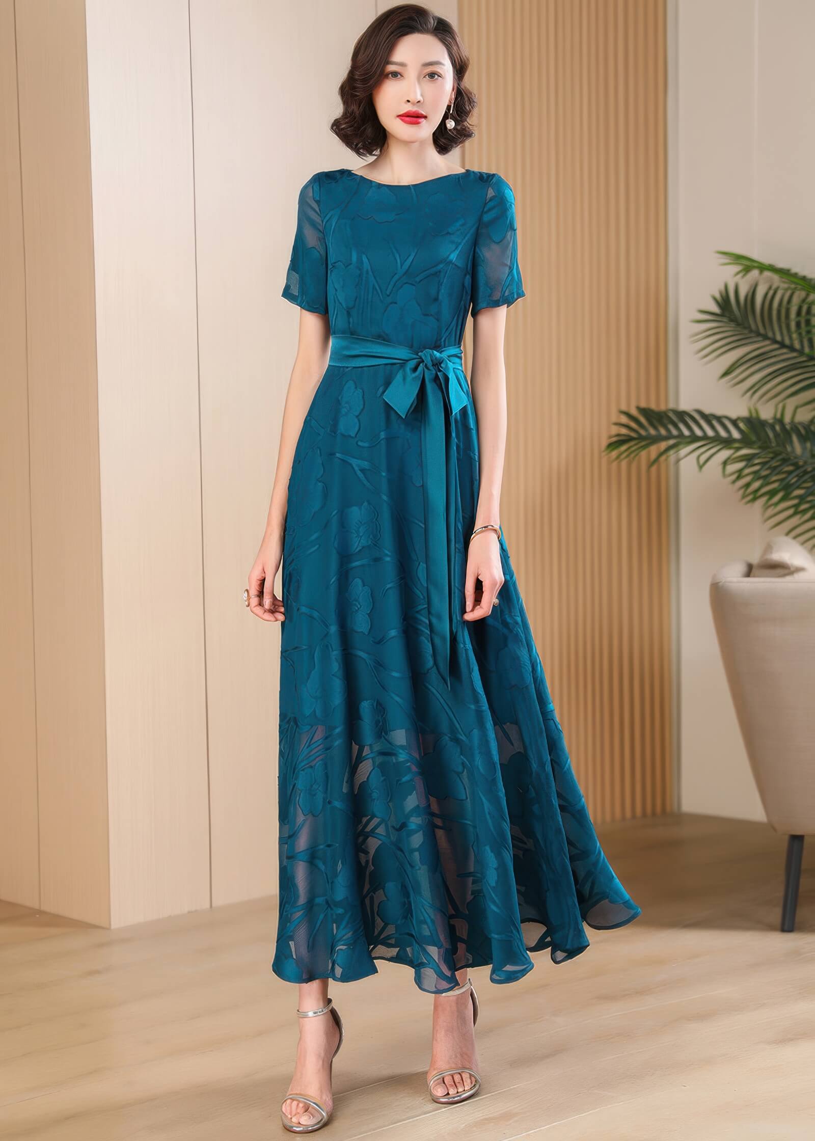 Model posing in the Elegant Green Floral Jacquard Maxi Dress, showcasing the rich teal-green color and floor-length hem.