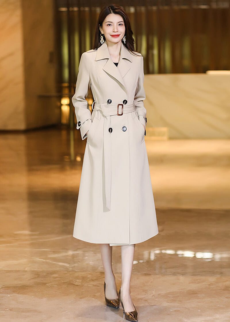 Elegant Vivian Seven beige long trench coat with double-breasted buttons and an adjustable waist belt.