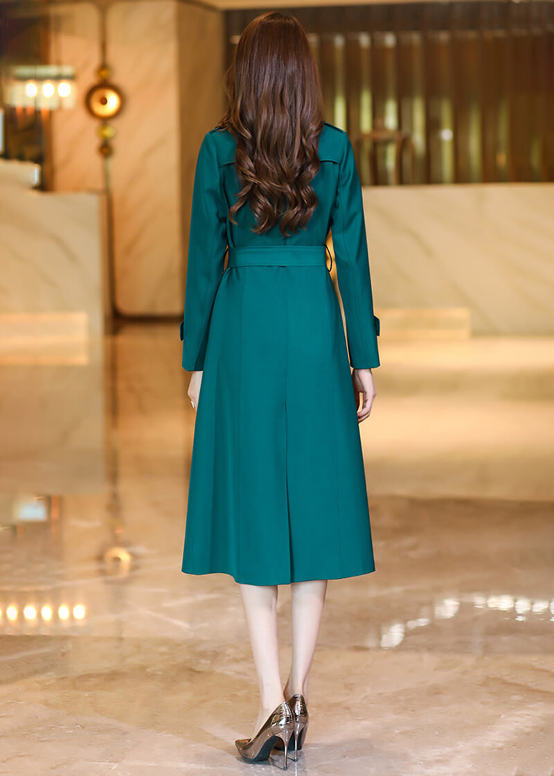Back view of the Vivian Seven peacock green trench coat showing the structured silhouette, waist tie, and elegant hemline.