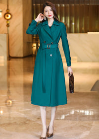 Full-length front view of a Vivian Seven peacock green long trench coat with a cinched waist and double-breasted buttons.