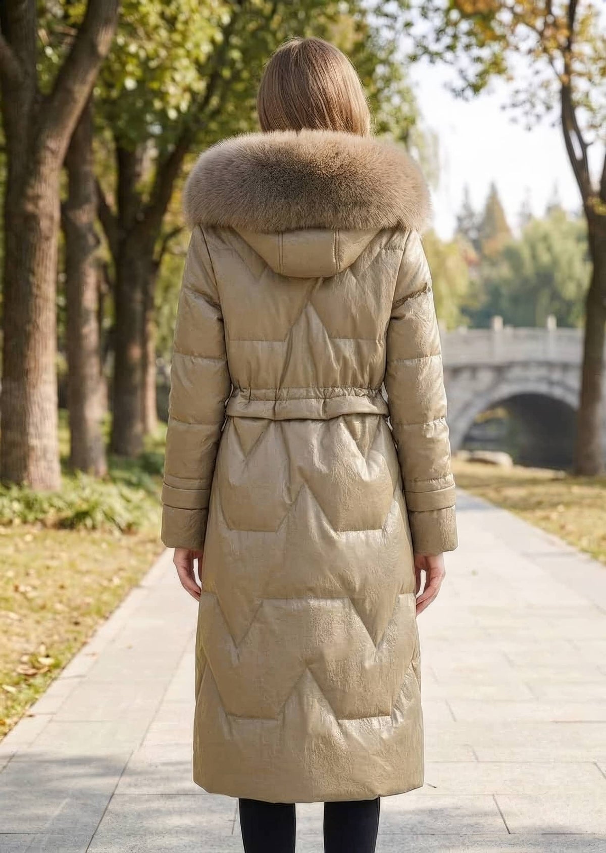 Full length back view of woman wearing khaki genuine sheepskin leather down coat with plush fox fur trim hood