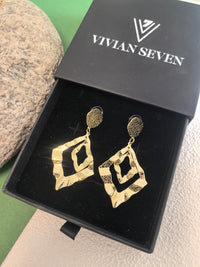 Pair of textured gold diamond-shaped earrings nestled inside a black velvet-lined "Vivian Seven" jewelry box.