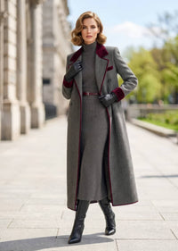 Woman posing outdoors wearing open grey herringbone double-breasted long coat over ribbed turtleneck sweater dress
