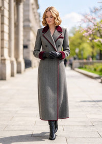Front portrait shot of woman wearing buttoned grey herringbone double-breasted coat with black leather gloves