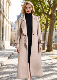 Full front view of woman wearing unbelted beige herringbone wool cashmere long coat outdoors