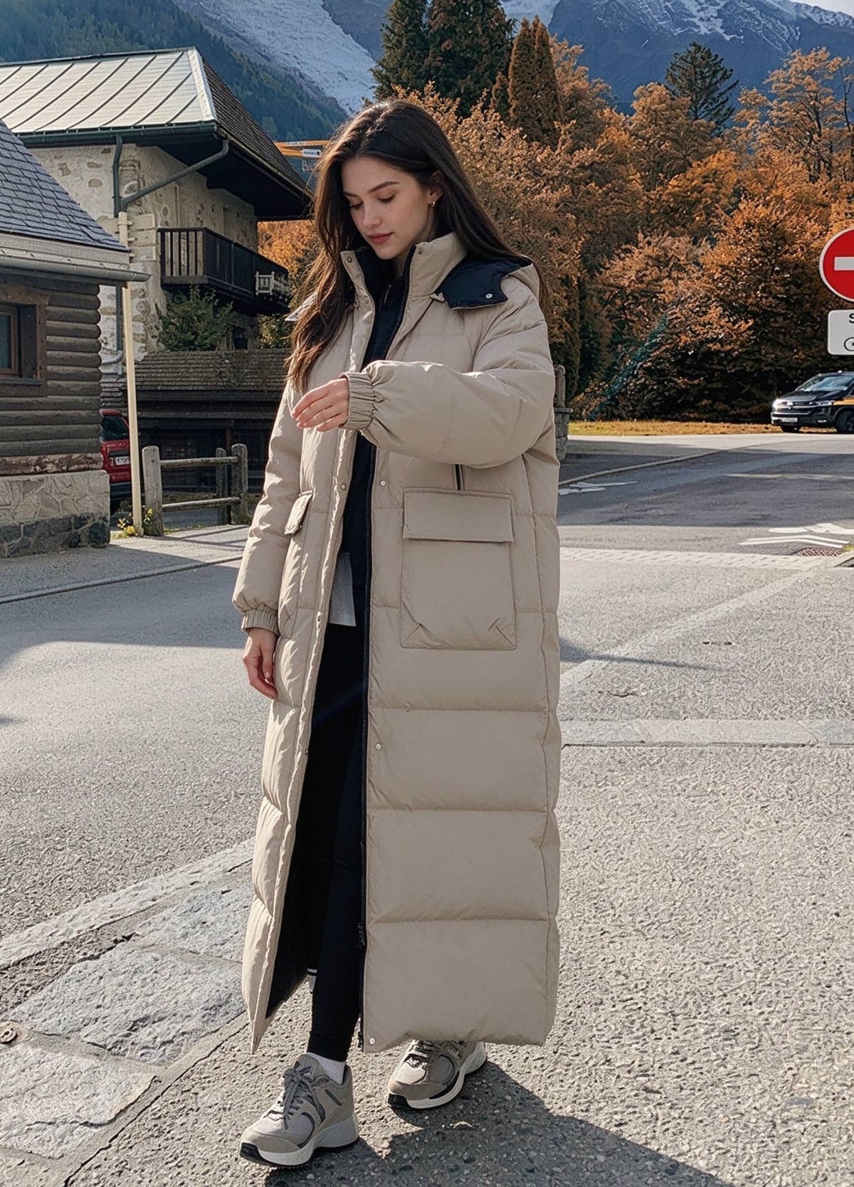 Full length front view of woman walking outdoors in beige hooded longline puffer parka with cargo flap pockets