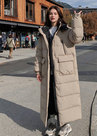 Full length front portrait of woman raising hand wearing beige hooded longline polyfill puffer parka