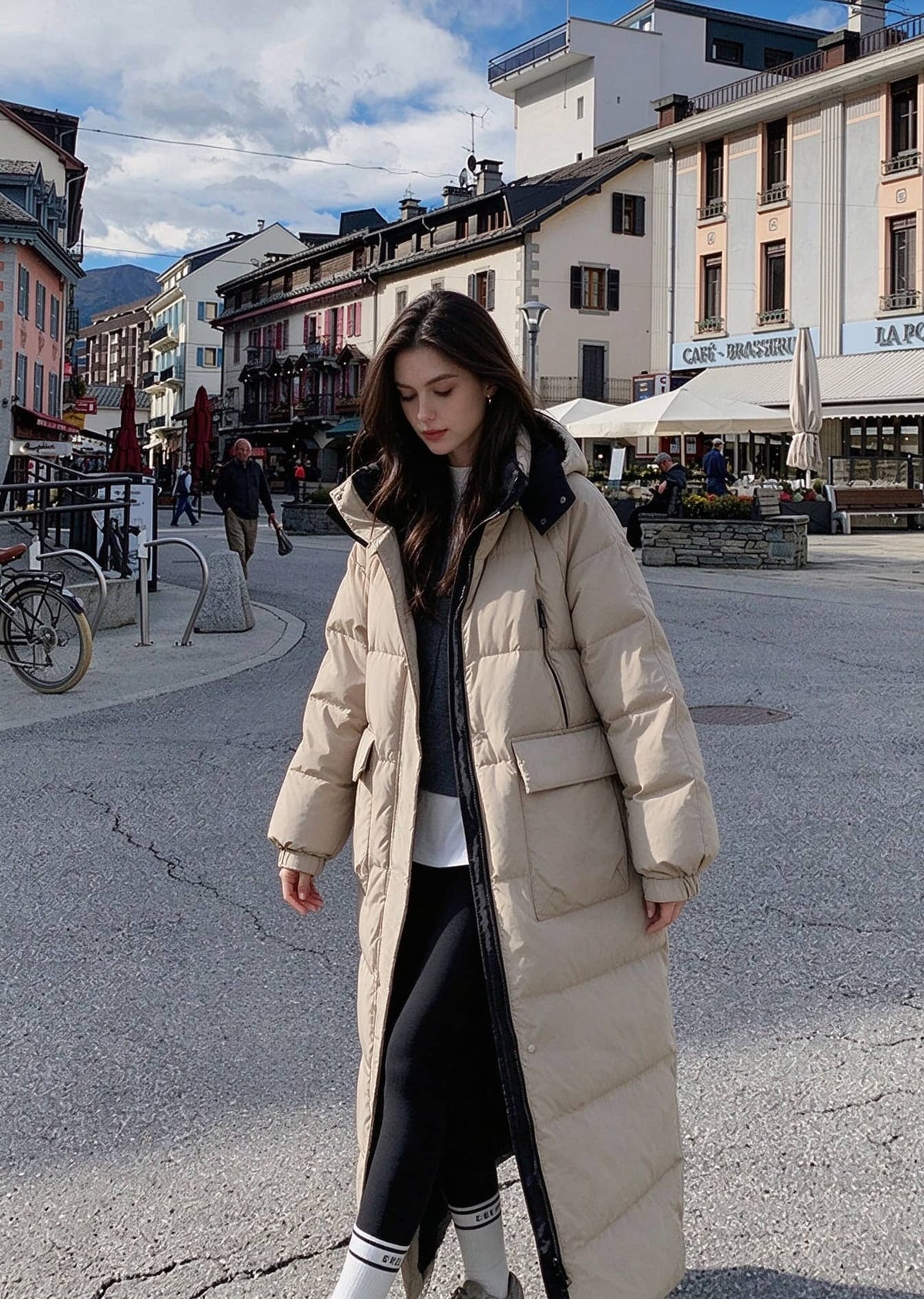 Full length view of woman walking in street wearing beige unzipped longline puffer parka with cargo flap pockets