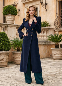 Full length pose of woman wearing navy blue double-breasted corduroy coat with bell cuffs and wide-leg trousers