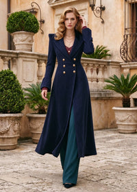 Full length front view of woman walking in navy blue double-breasted corduroy fit and flare long coat with gold buttons