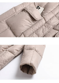 Close-up detail of front flap pocket and sleeve cuff on beige longline down parka coat