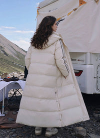Full length back side view of woman wearing off-white side-stripe longline puffer coat with detachable hood