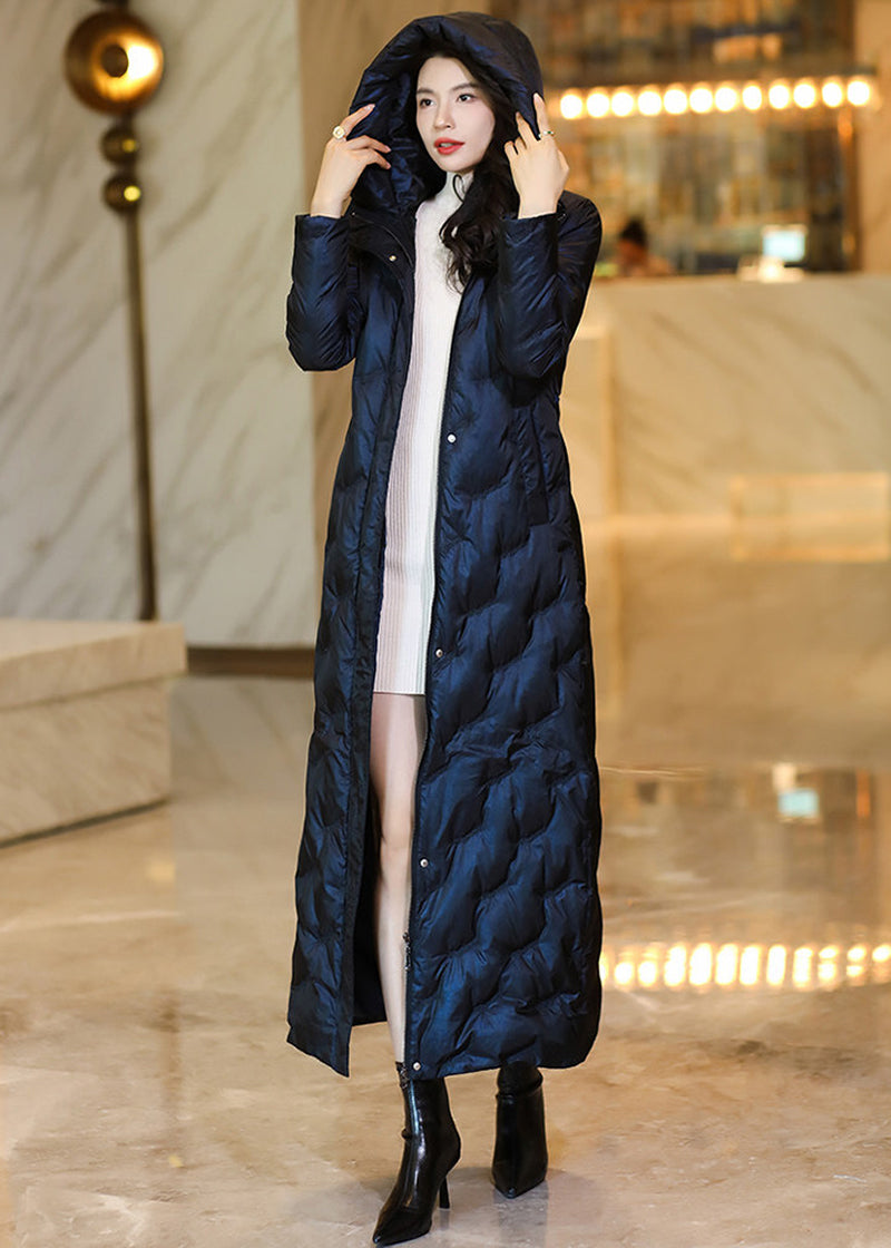 Model wearing an open-style midnight navy full-length hooded down parka over a white sweater dress