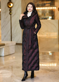 Full-length frontal view of a model in a deep shimmering burgundy belted down coat with high collar