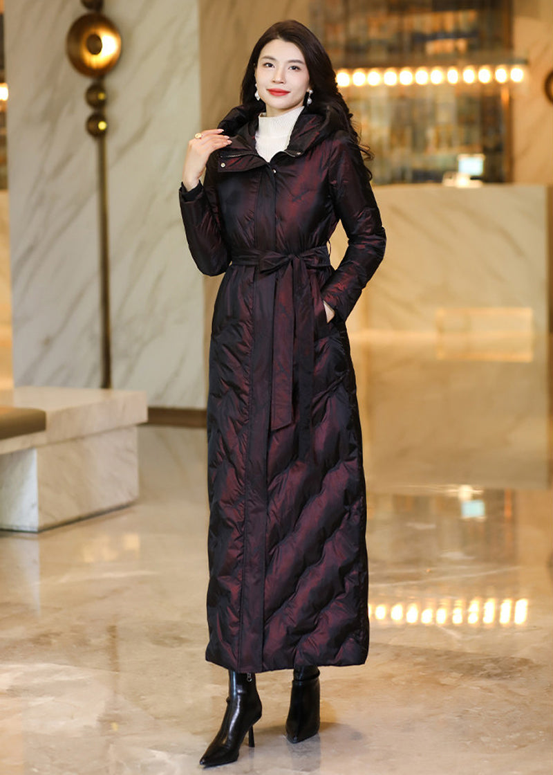 Full-length frontal view of a model in a deep shimmering burgundy belted down coat with high collar
