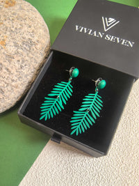 A pair of dark green fern-leaf dangle earrings presented inside a black jewelry box with the brand name ""VIVIAN SEVEN"" visible on the lid.