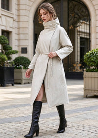 Woman walking outdoors in beige asymmetric high neck longline down coat with braided rope belt