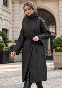 Woman walking in black asymmetric high neck longline down coat with side rope tie