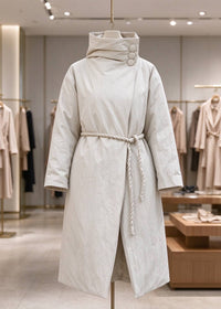 Beige high neck asymmetric longline down coat with braided rope belt on mannequin display