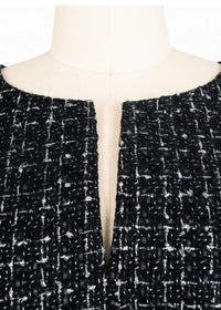 Close-up detail of the Vivian Seven black tweed neckline, showing the intricate weave of the fabric and the subtle front slit.
