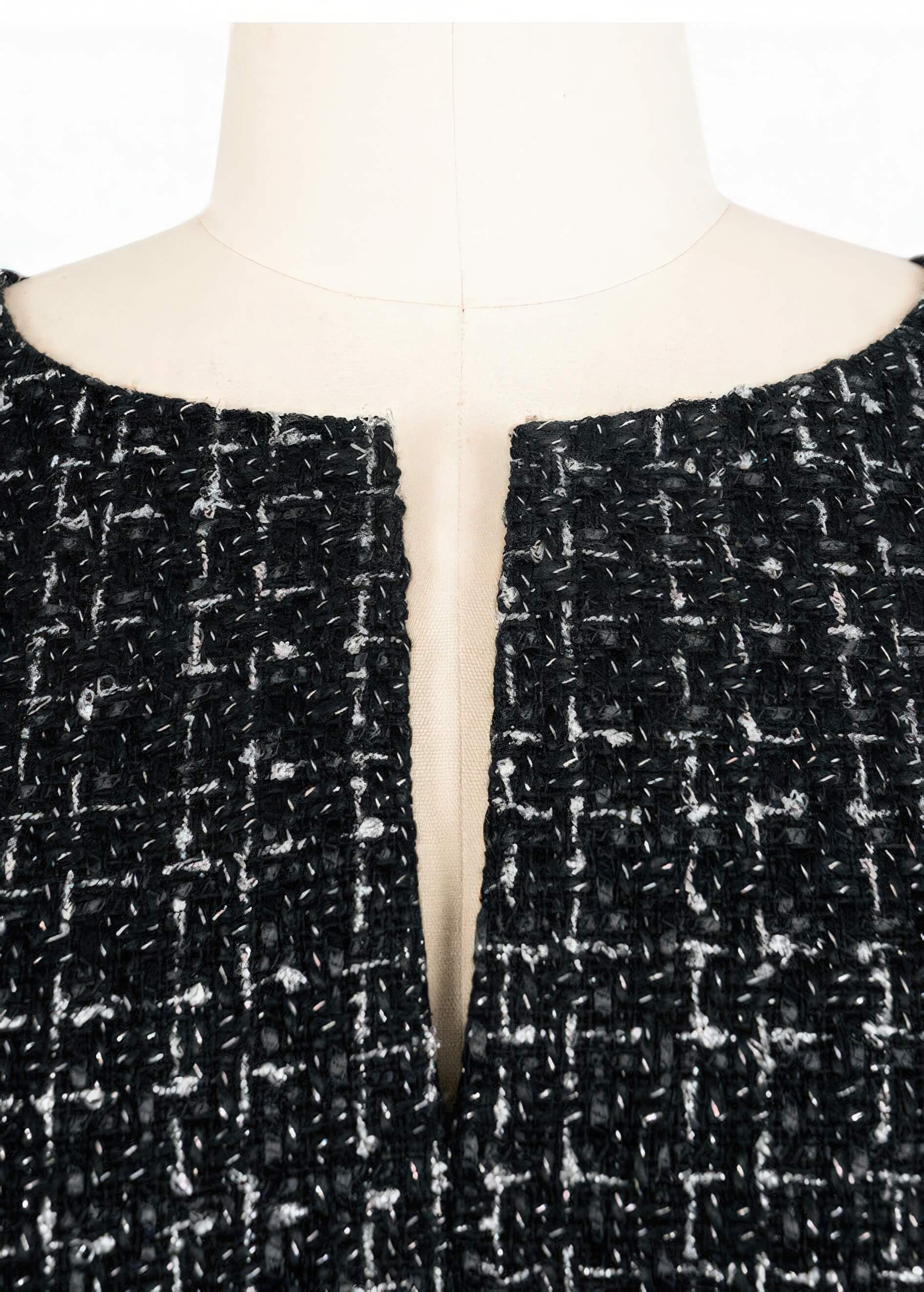 Close-up detail of the Vivian Seven black tweed neckline, showing the intricate weave of the fabric and the subtle front slit.