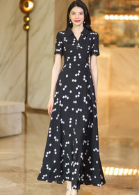 A woman gracefully posing in a flowing polka dot maxi dress, highlighting the elegant drape of the fabric.