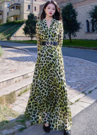 Full-length portrait of the Vivian Seven leopard print gown, highlighting the cinched belted waist and elegant A-line silhouette against a European-style architectural background.