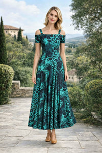 Full-length straight-on studio-style outdoor shot of a blonde woman posing naturally in an emerald green and black leopard print off-the-shoulder A-line maxi dress.