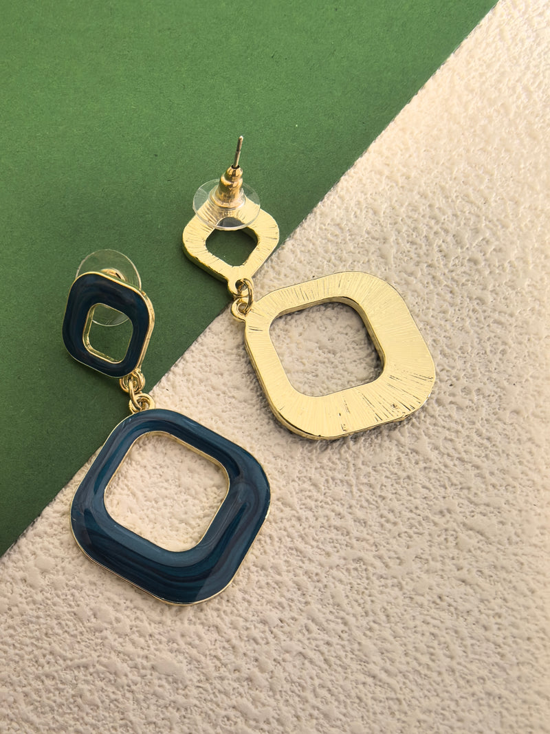 A close-up shot of the backside of the blue enamel earrings, revealing the gold-toned base and the post closure.