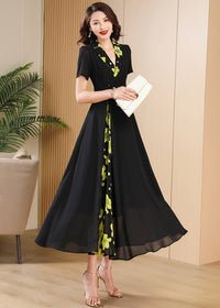 Dynamic Pose,Full-length view of a flowing black summer maxi dress with short sleeves and a decorative floral vertical panel.