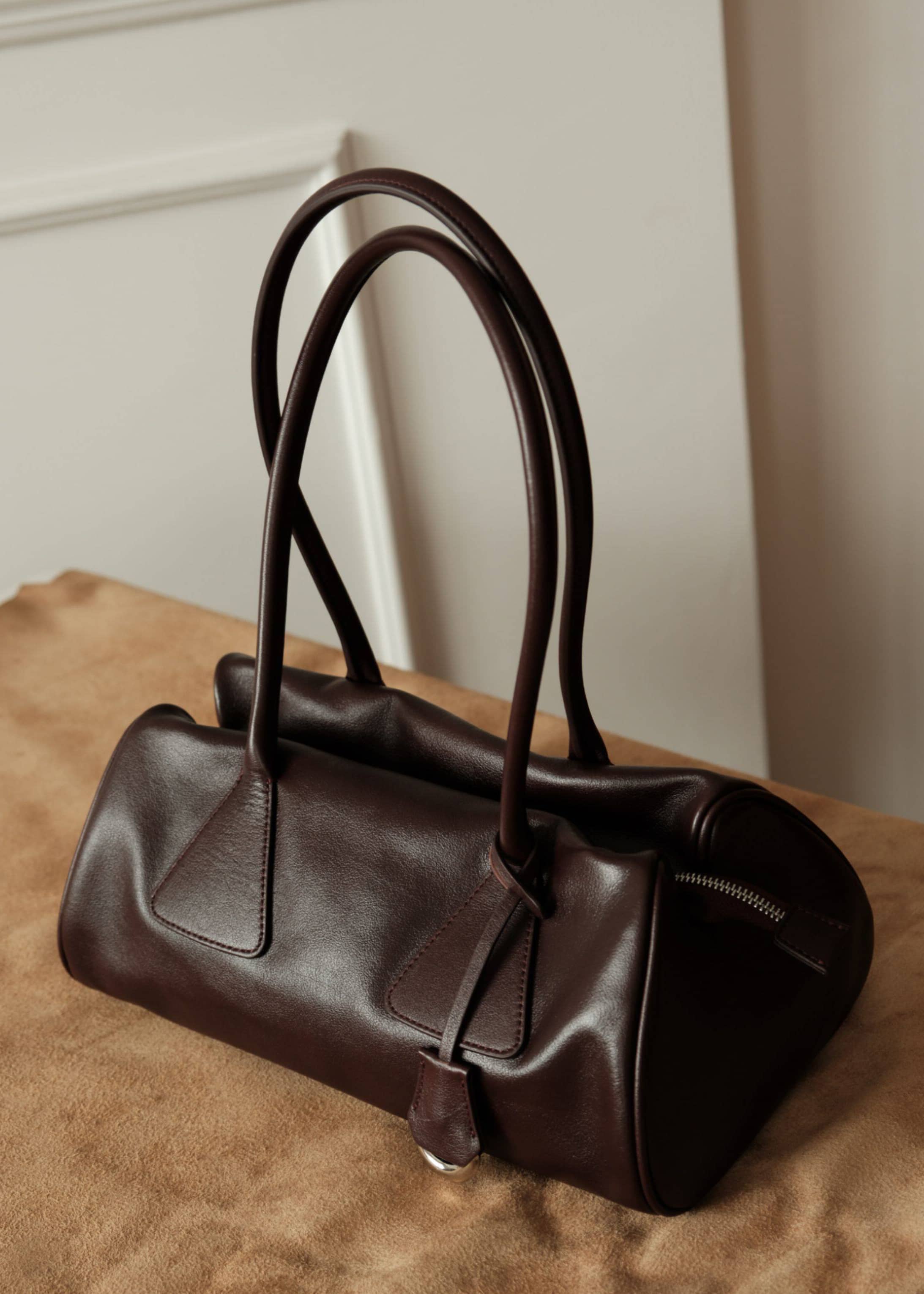 Burgundy brown genuine leather shoulder bag featuring a key ring charm and silver hardware zipper