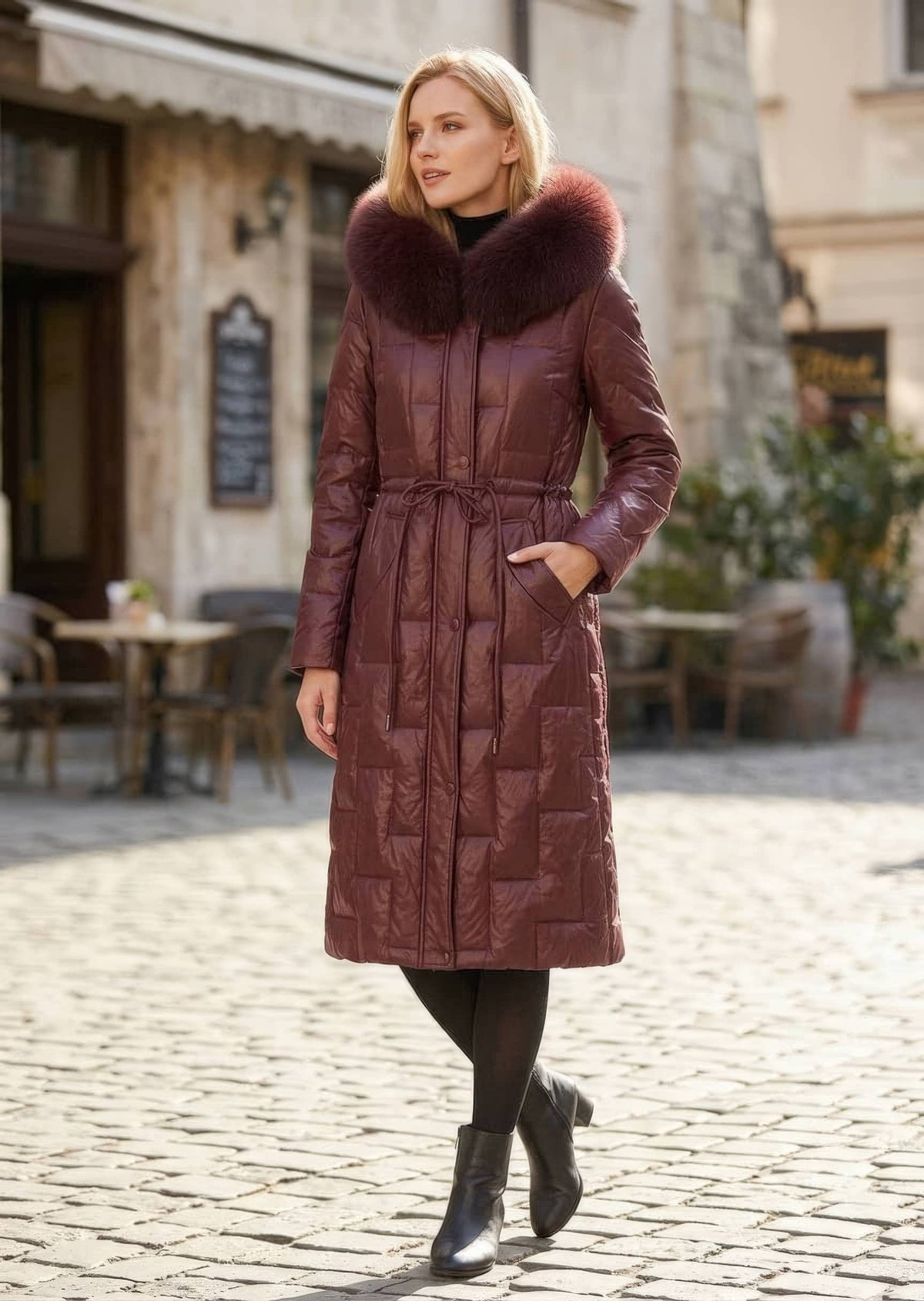 Three-quarter view of woman with hand in pocket wearing burgundy Vivian Seven genuine leather puffer long down parka