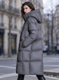 Three-quarter side view of woman wearing dark grey high funnel hooded down puffer parka coat