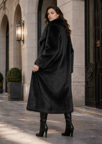 Three-quarter back view of woman looking over her shoulder in a long wide-collar black faux fur winter coat