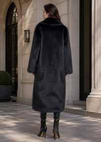 Full-length back view of a luxury longline black faux fur coat styled with black knee-high leather boots
