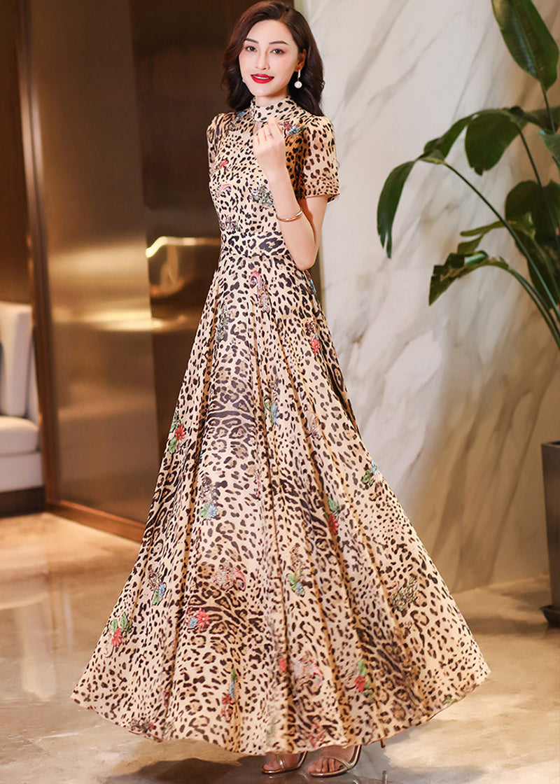 Side-angle view of a woman posing in a pleated leopard print maxi dress with a voluminous skirt.