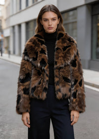 Portrait shot of a female model wearing a brown abstract spot cropped faux fur coat over a black turtleneck sweater.
