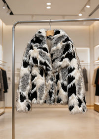 Black and cream white abstract leopard pattern cropped faux fur coat on a clothes hanger by Vivian Seven.