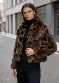 Side angle of a model wearing a brown and black cropped faux fur jacket with lapel collar by Vivian Seven.