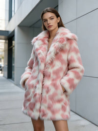 Model with hands in pockets posing against a modern grey building in a blush pink patterned faux fur coat.