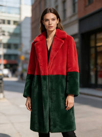 Model wearing a red and dark green bold statement colorblock faux fur long coat outdoors.